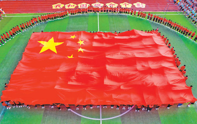 国庆前夕，江西省新余市高新三小举行“我和国旗合个影”爱国主义主题活动，庆祝新中国成立72周年。赵春亮摄（影像中国）