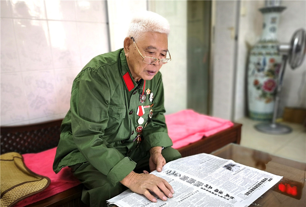 李延年在广西南宁家里看报纸(2019年7月14日摄).