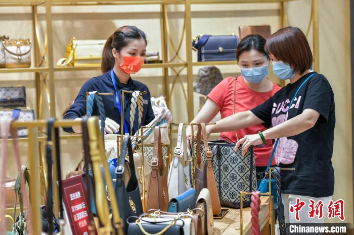 “十一”假期顾客在免税店选购箱包。 骆云飞 摄