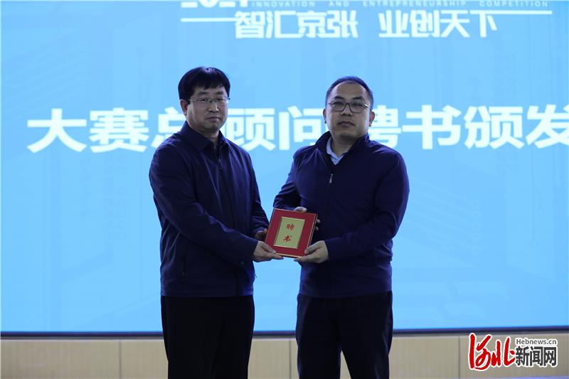 图为张家口市科学技术局局长殷飞(左)为大赛总顾问宁金彪颁发聘书.