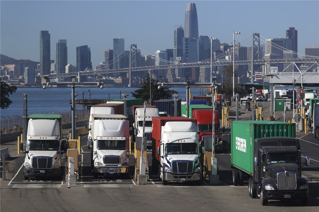 △10月14日，运送集装箱的卡车离开美国加州奥克兰港码头。（图自视觉中国）