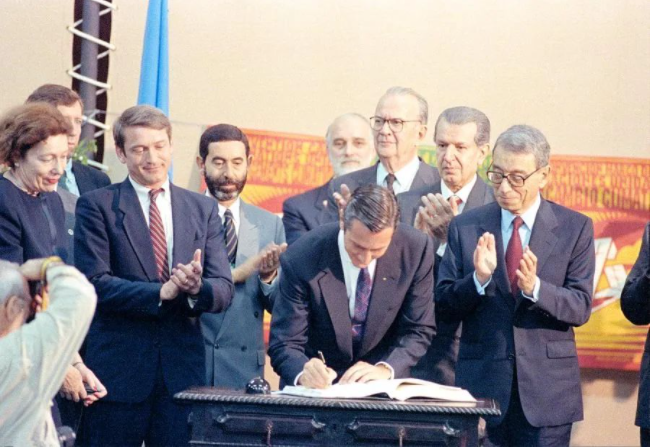△1992 年里约大会上，各国领导人在时任联合国秘书长布特罗斯·加利（右）的见证下踊跃签署《生物多样性公约》。但美国时任总统老布什没有签署。