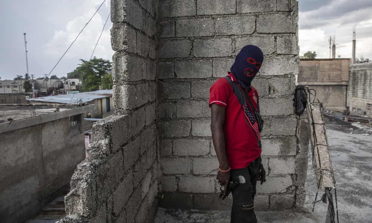 ▲海地太子港，一名蒙面持枪的帮派成员。图据网络