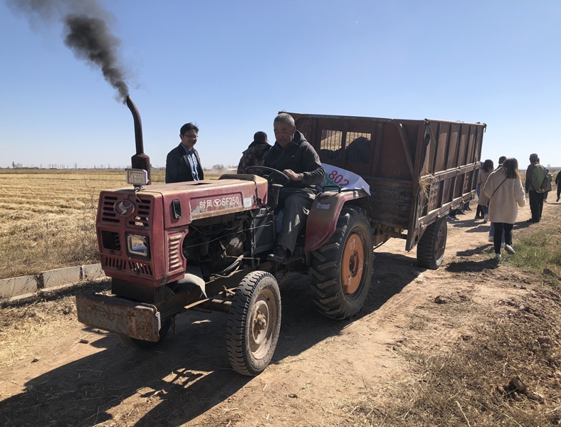 沙圪堵村村民开着拖拉机,准备拉着稻谷回去脱壳.