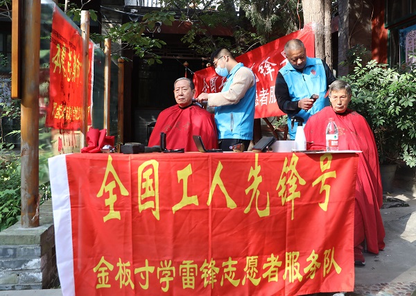 北京金板寸文化发展中心志愿者服务队为居民开展义务理发服务。