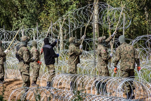 波兰士兵正在边境架设铁丝网。图源：视觉中国