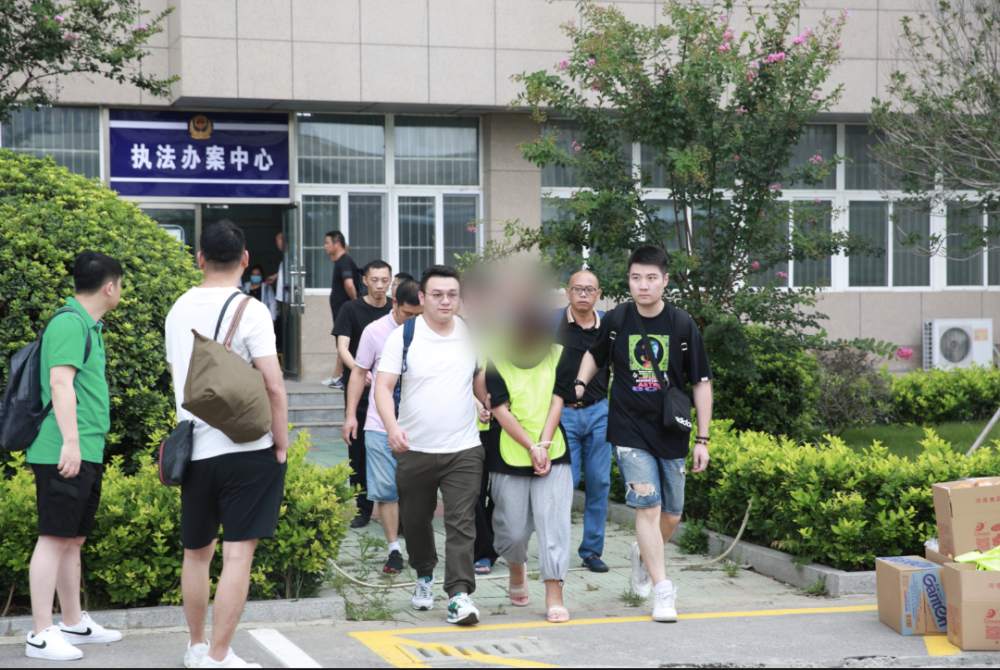 上海警方将犯罪嫌疑人押解回沪。上海奉贤警方供图