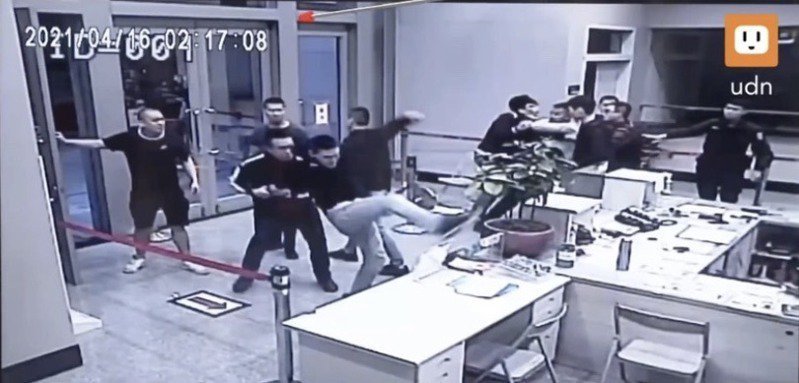 黑衣人闯入警局打砸警用电脑显示器。图自台湾“联合新闻网”