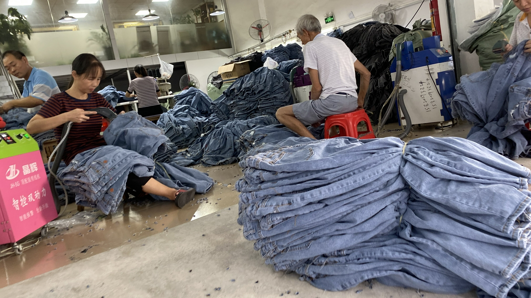 工人在用机器清理牛仔裤的线头  时代周报记者黎广/摄