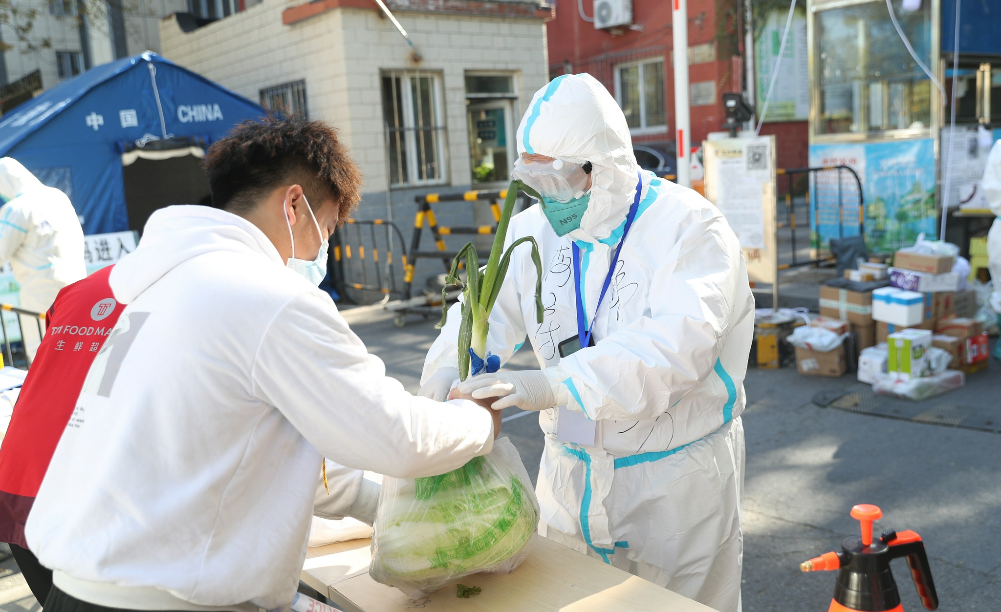 10月27日，外卖配送员将物品递给工作人员。（中国日报记者 邹红 摄）