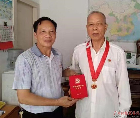 黄俊明佩戴光荣在党50年徽章。