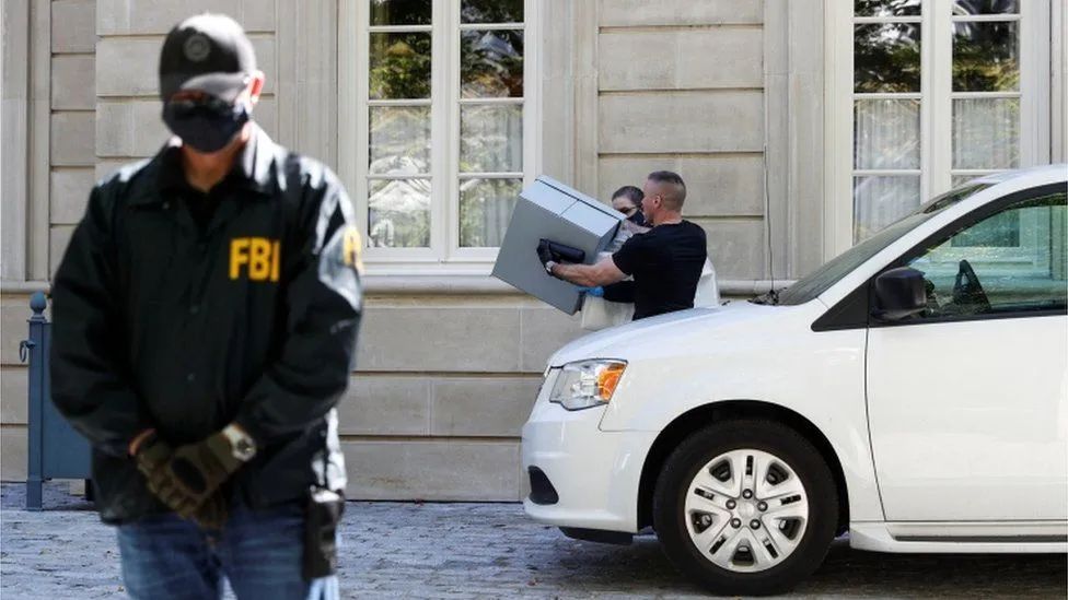 ·FBI特工将一些箱子从豪宅中搬出。
