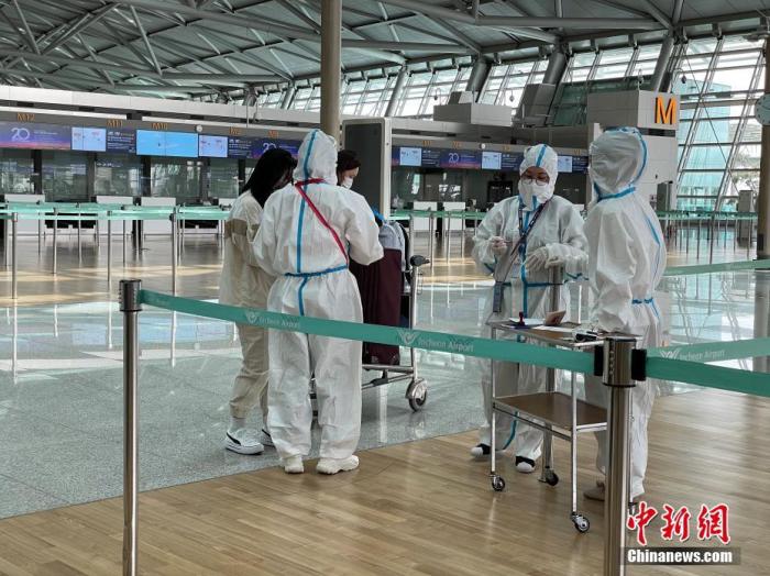 资料图:韩国仁川国际机场工作人员严格执行防疫措施。中新社记者 刘旭 摄