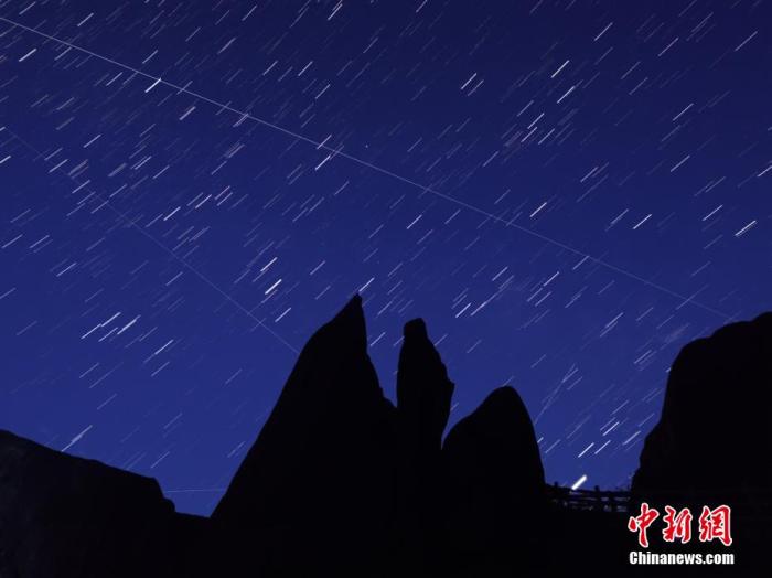 △北半球三大流星雨之一的英仙座流星雨现身夜空。在安徽黄山之巅，流星穿梭银河交相辉映。星空璀璨，群山绵延，黄山之巅蔚然壮观。