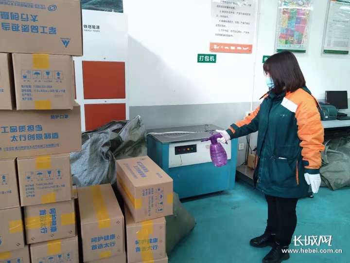 邮政快递人员对货物进行消毒.石家庄市邮政局供图