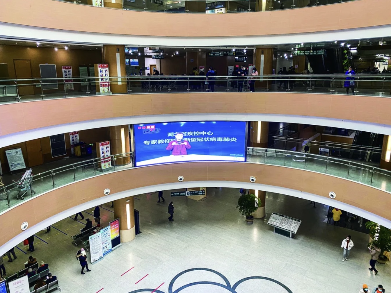 (2020年12月9日,武汉中心医院后湖园区门诊楼内,大屏幕循环播放防控新