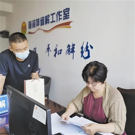 (2021年8月16日,籍润萍(右)在调解室就一件劳动合同纠纷案耐心做当事