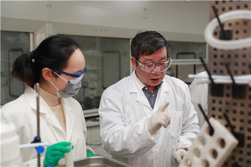 赵东元（右）和团队成员在实验室讨论交流。 复旦大学供图