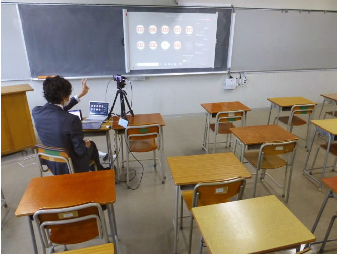 一位教师在没有学生的教室里进行线上授课。（图片来源：共同社）