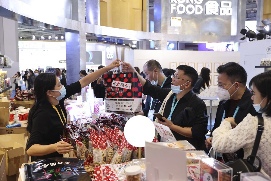11月6日，观众在食品及农产品展区选购美食。（中国日报记者 冯永斌 摄）