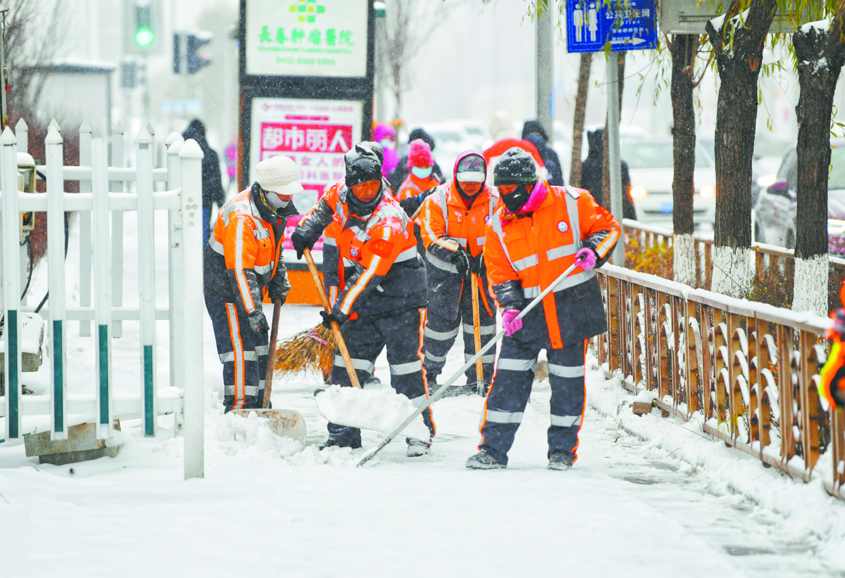 环卫工人正在清理人行步道积雪. 张扬 摄