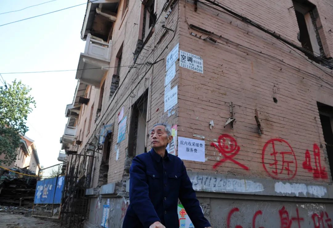 一位花甲老人在建于上世纪50年代的华北制药职工宿舍前驻足。图/中新图片