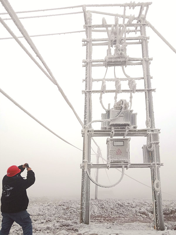 1月10日，南方电网云南电网公司红河泸西供电局向阳供电所的工作人员冒着严寒巡视线路，对覆冰变压器进行观测 图片来源：南方电网