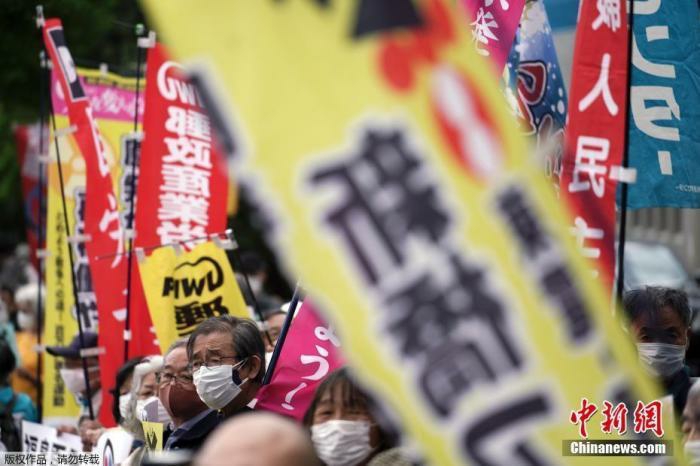 资料图：当地时间2021年4月13日，日本政府正式决定，将福岛核污水经过滤并稀释后排放入海。图为日本民众举行抗议活动。