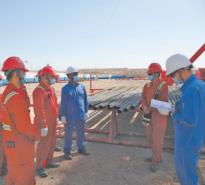 伊拉克米桑油田项目建设有力促进了当地配套产业发展，增进民生福祉。图为2021年9月，在米桑油田，中伊双方员工正在进行技术沟通。