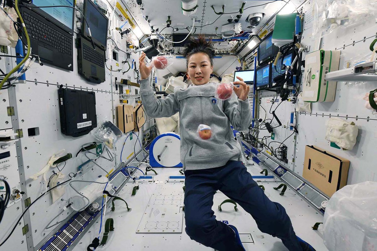 航天员王亚平在天和核心舱内吃苹果，吃前还能玩个杂技。 （图片来源：中国航天员中心）
