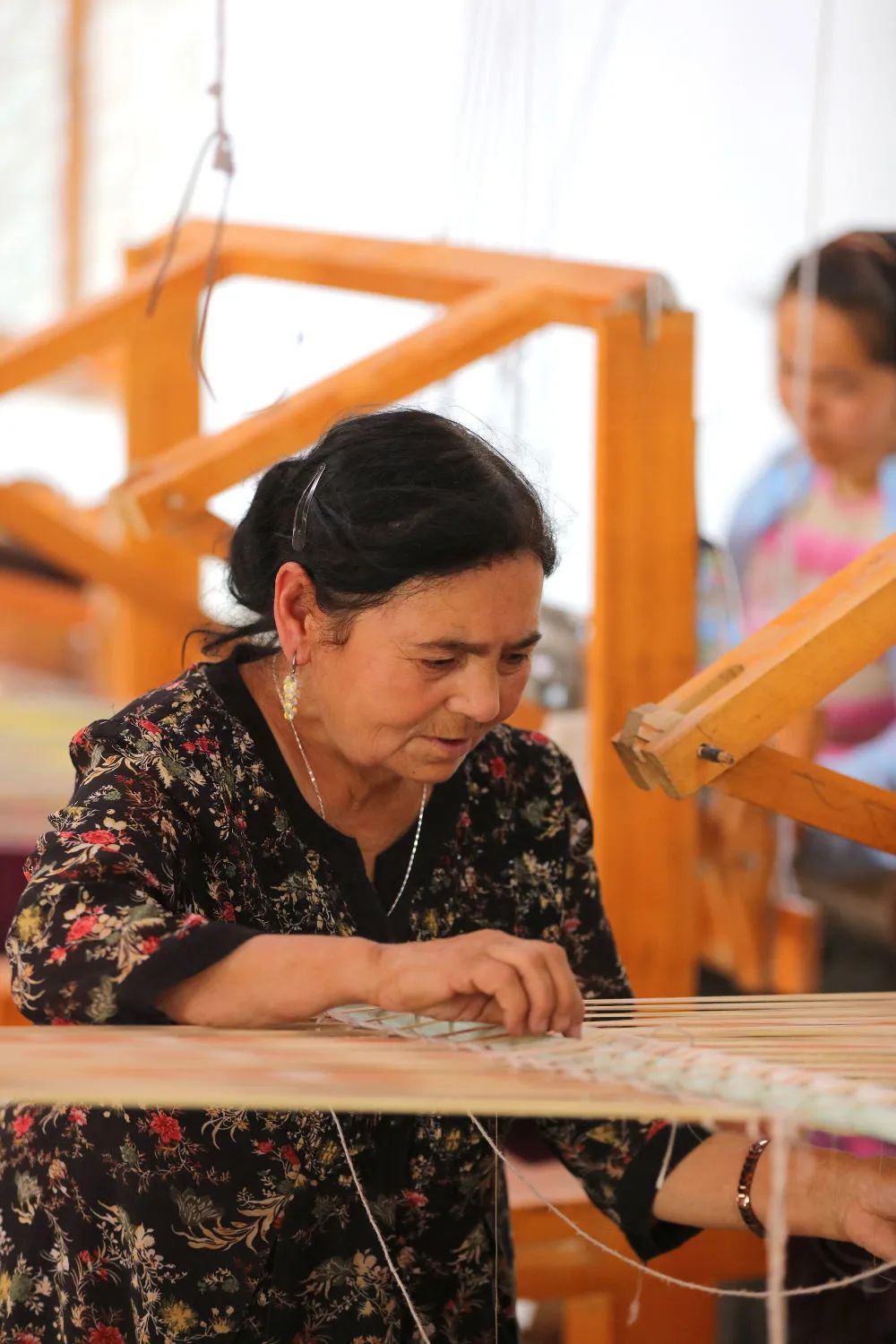 "吉亚丽人"艾德莱斯绸加工厂的工人正在纺绸.(受访者供图)