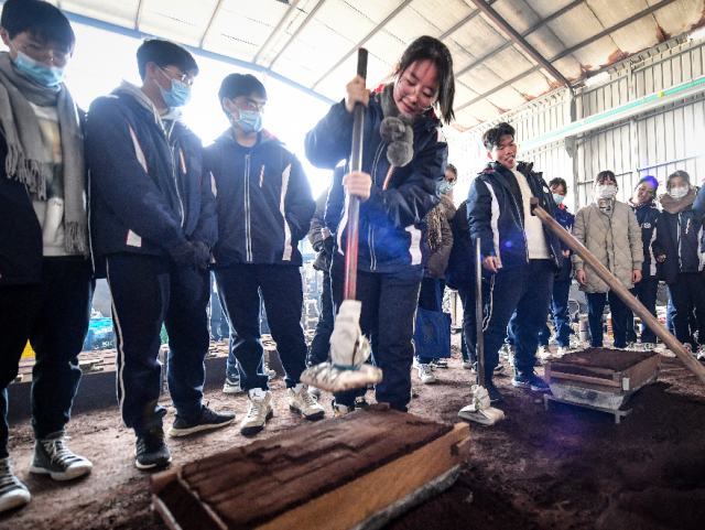 图为学生们正在制作浇注用的模具 严龙 摄