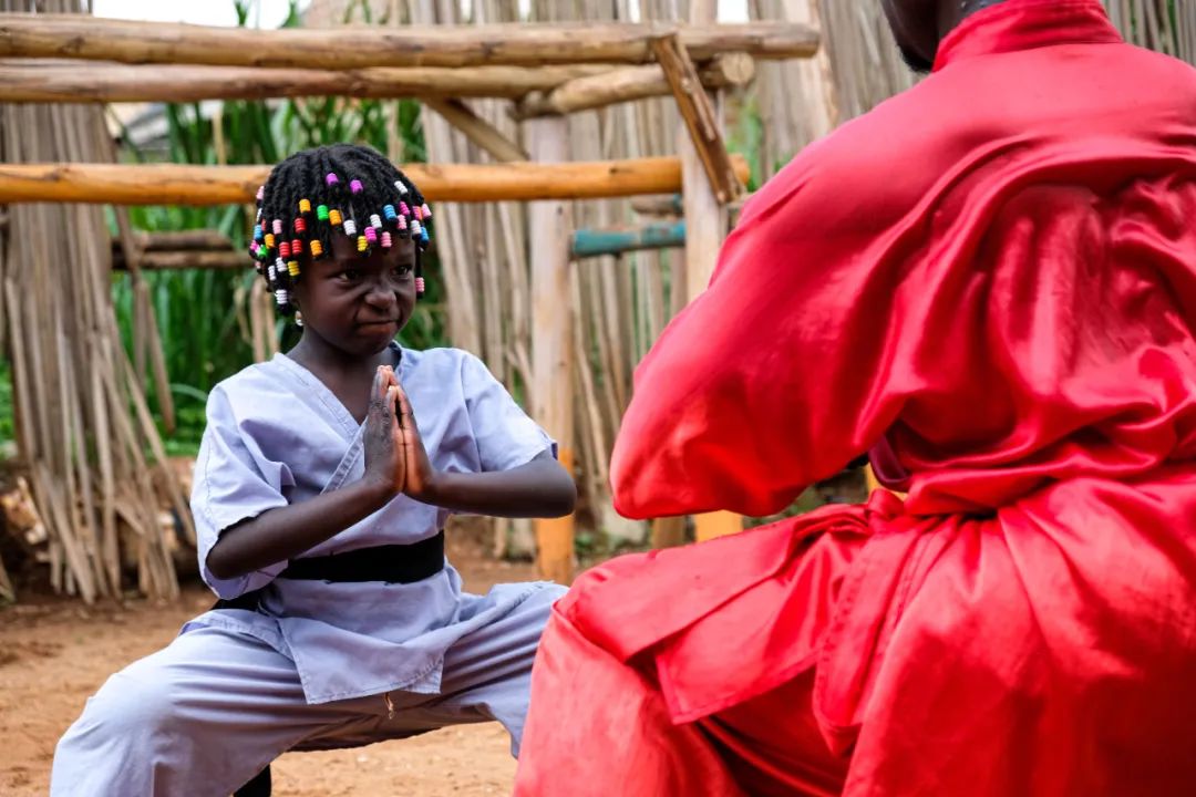 2021年8月23日，在乌干达瓦基索区的卡图克镇，武术教练基扎·玛尼苏鲁·塞吉姆巴正在教他的五岁女儿中国功夫。新华社发