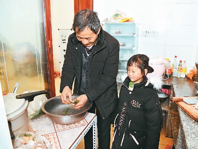 　李昌德在新家里洗菜做饭，李青怡陪伴着爷爷。