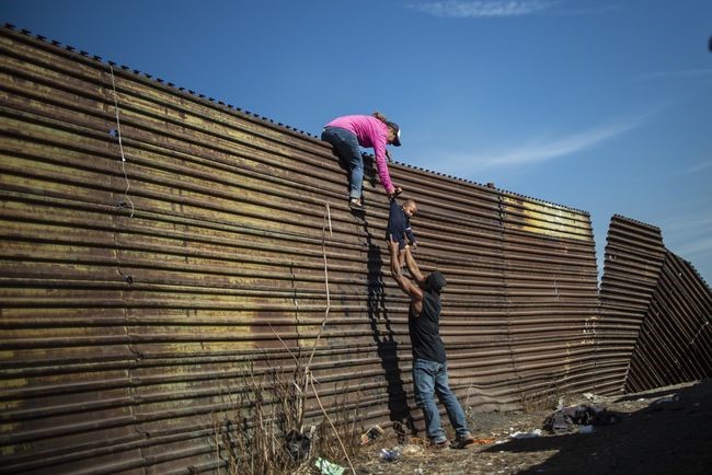  △移民翻越边境墙