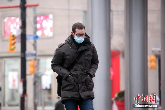 资料图：当地时间1月14日，佩戴口罩的民众行走在加拿大多伦多市中心街头。多伦多所在的加拿大人口第一大省安大略省从当天开始实施“居家令”。中新社记者 余瑞冬 摄