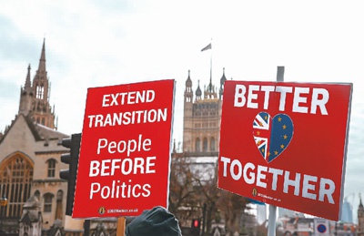 2020年12月9日，示威者手举“反对脱欧”的标语牌站在英国伦敦议会大厦外。新华社记者 韩 岩摄
