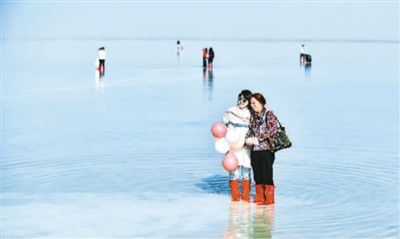 　　游客在青海茶卡盐湖“天空之镜”景区游玩。　　新华社记者 张 龙摄