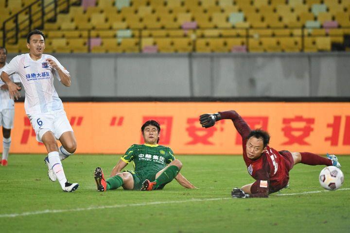 △8月15日，北京国安队球员张玉宁（中）在比赛中射门得分。