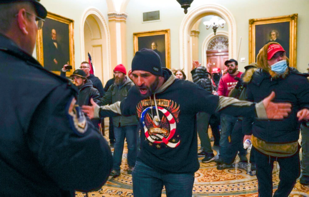 q"标志服饰的男子,在华盛顿州国会大厦参议院会议厅外的走廊与美国