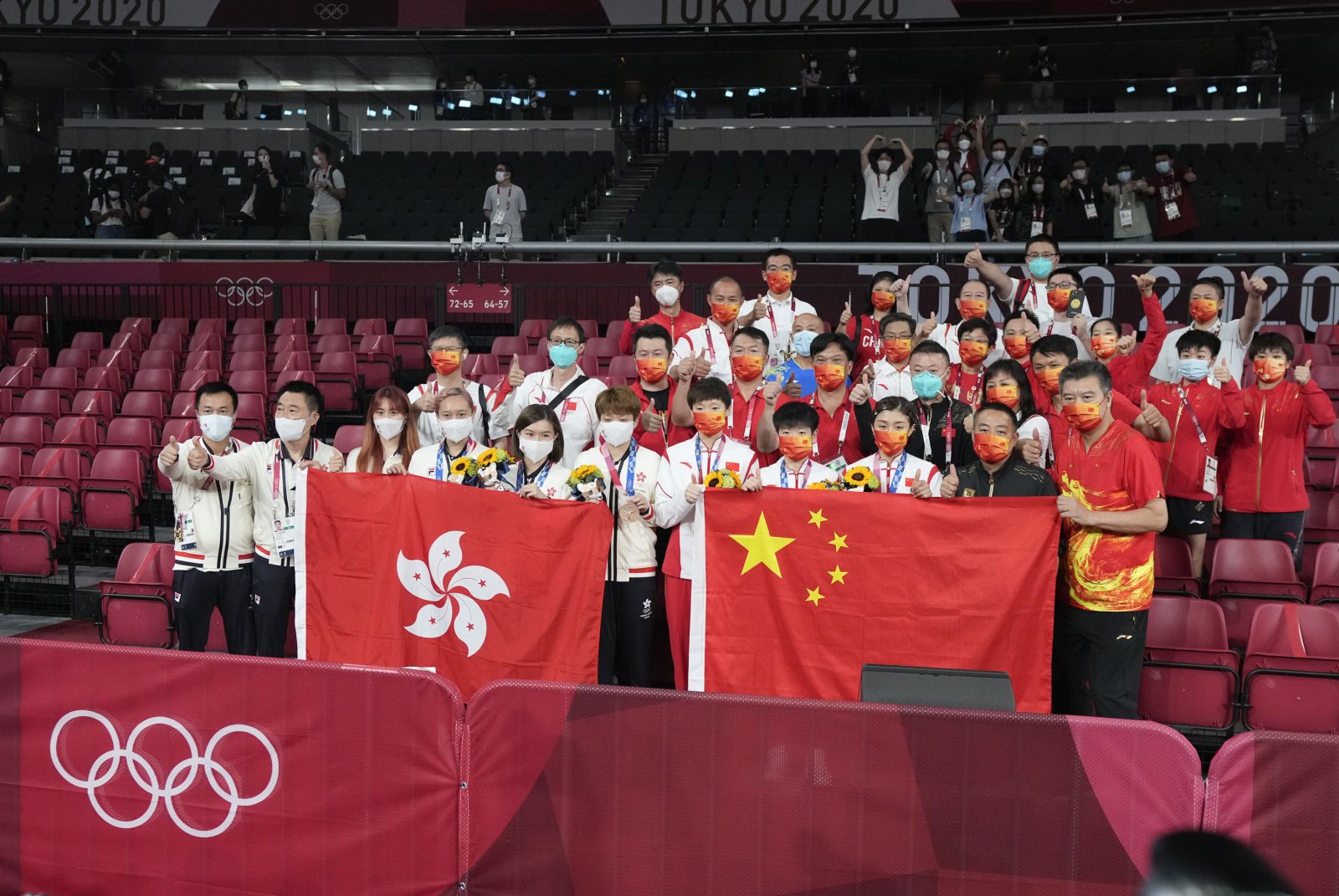 东京奥运会，国家队、中国香港队队员同国旗、区旗一起合影。（资料图）