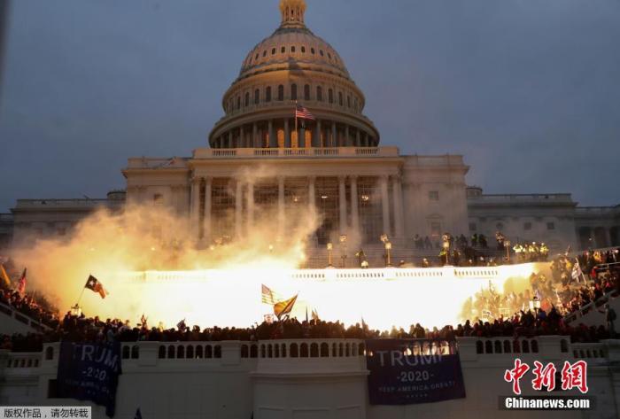 当地时间1月6日，美国参众两院确认选举人团投票结果的联席会议，因时任总统特朗普支持者闯入国会大厦引发大规模骚乱而被迫中断，现场极度混乱。图为美国华盛顿的美国国会大厦前火光四起。