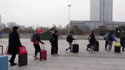 从火车站出来后，会有工作人员引导返乡人员到停车场上车。长城网记者 李丽钧 袁立朋 摄