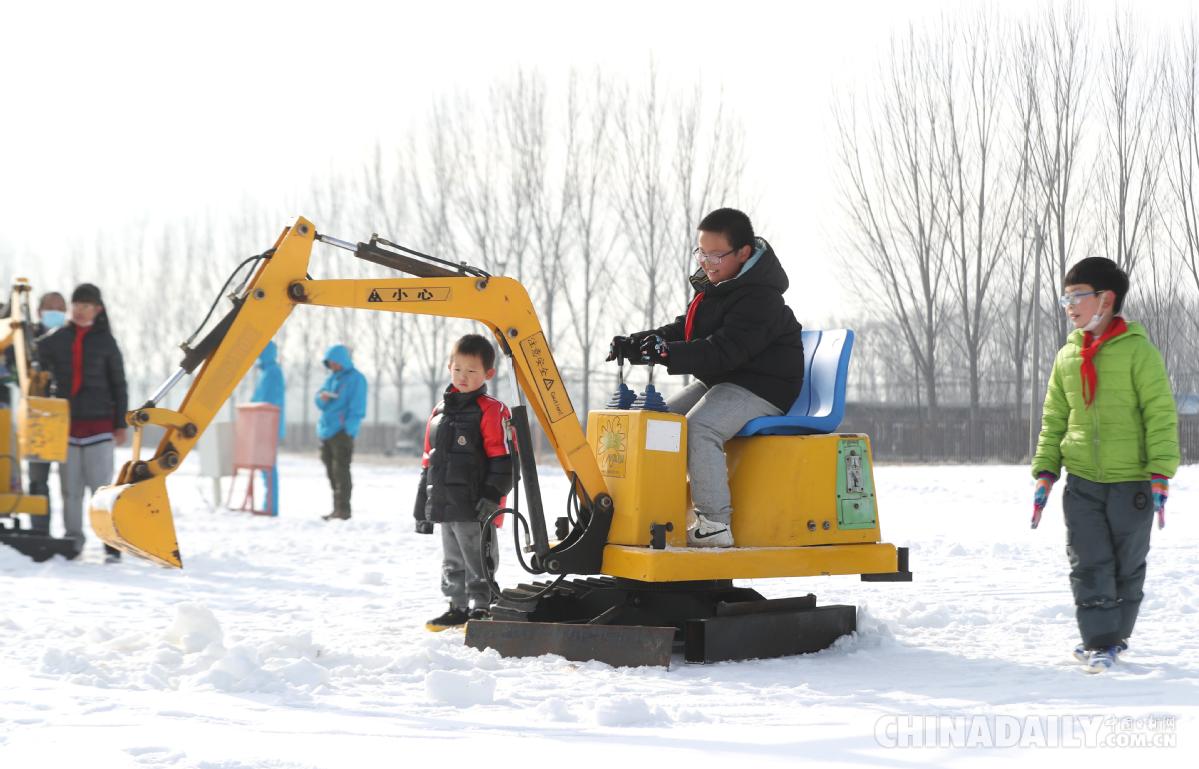 12月10日，小朋友体验雪地挖掘机。（中国日报记者邹红摄）