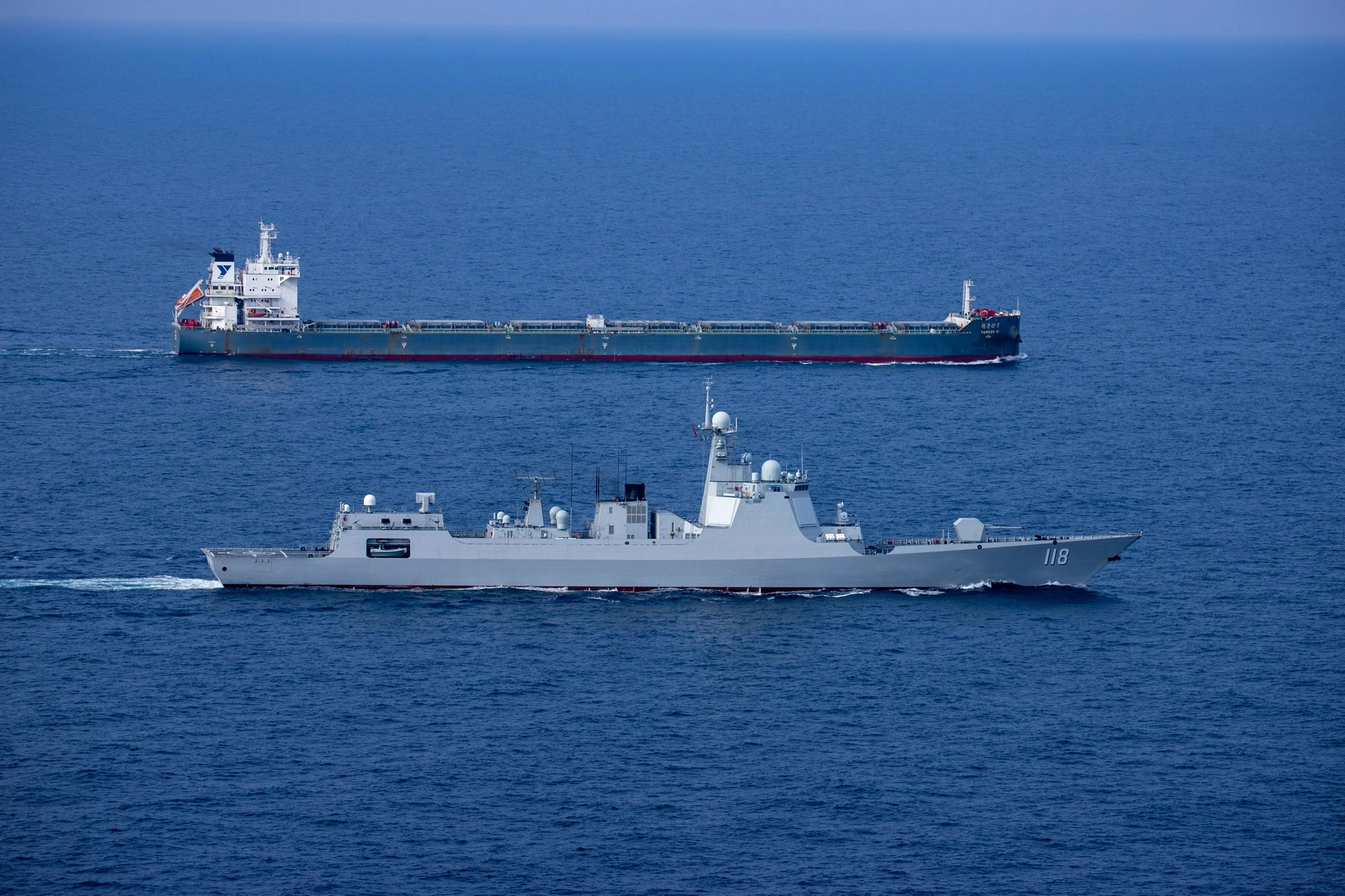 图为导弹驱逐舰乌鲁木齐舰为"扬子12"号货船实施伴随护航