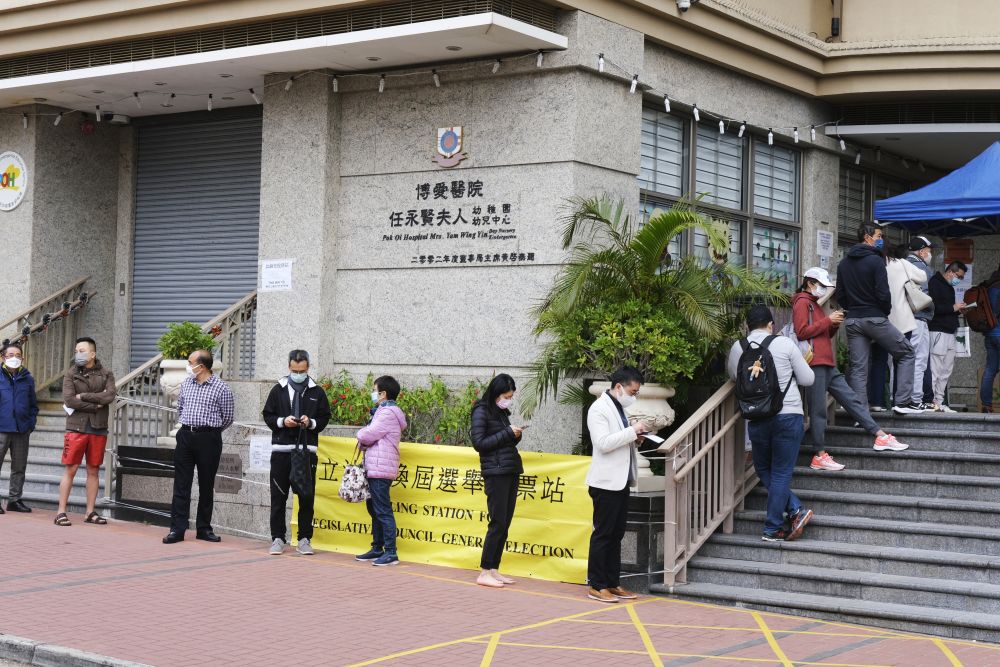 ↑12月19日，在位于荃湾天主教石钟山纪念小学投票站，选民陆续进入站内准备投票。新华社记者 卢炳辉 摄