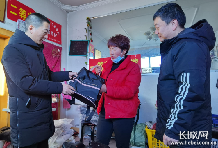 刘小平（中）向耿利红（右一）、贾永亮介绍企业的生产情况。长城网记者 郭庆敏 摄