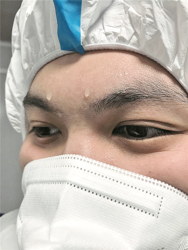 在防护服包裹下,护士的额头渗出汗珠.