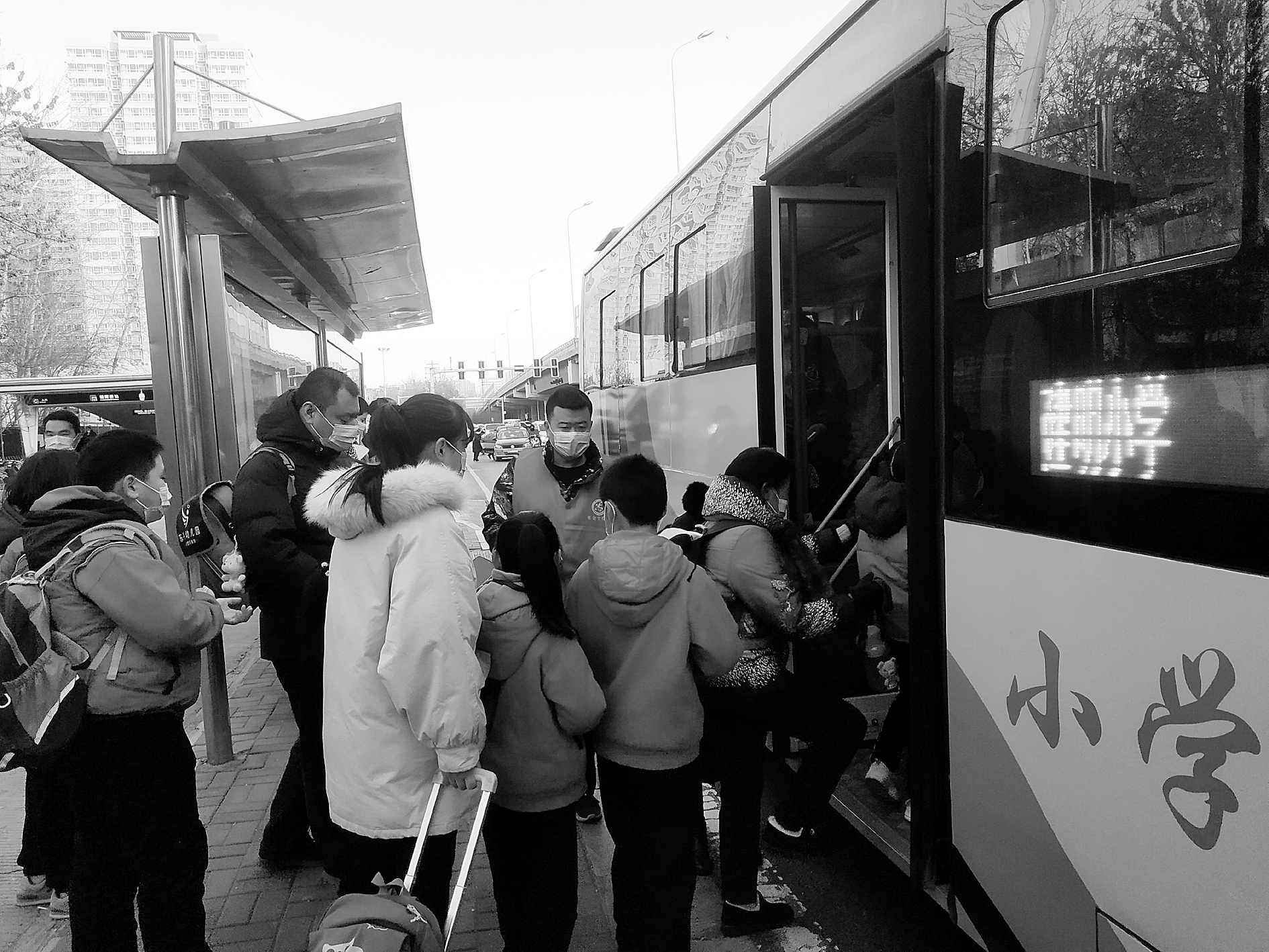 50多人排队乘坐建明小学免费专线公交车. 本报记者 南开宇 摄