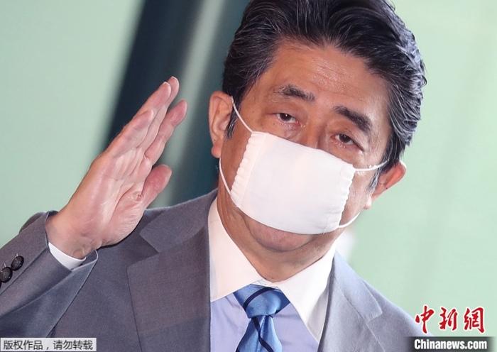 资料图：日本前首相安倍晋三佩戴“安倍口罩”。